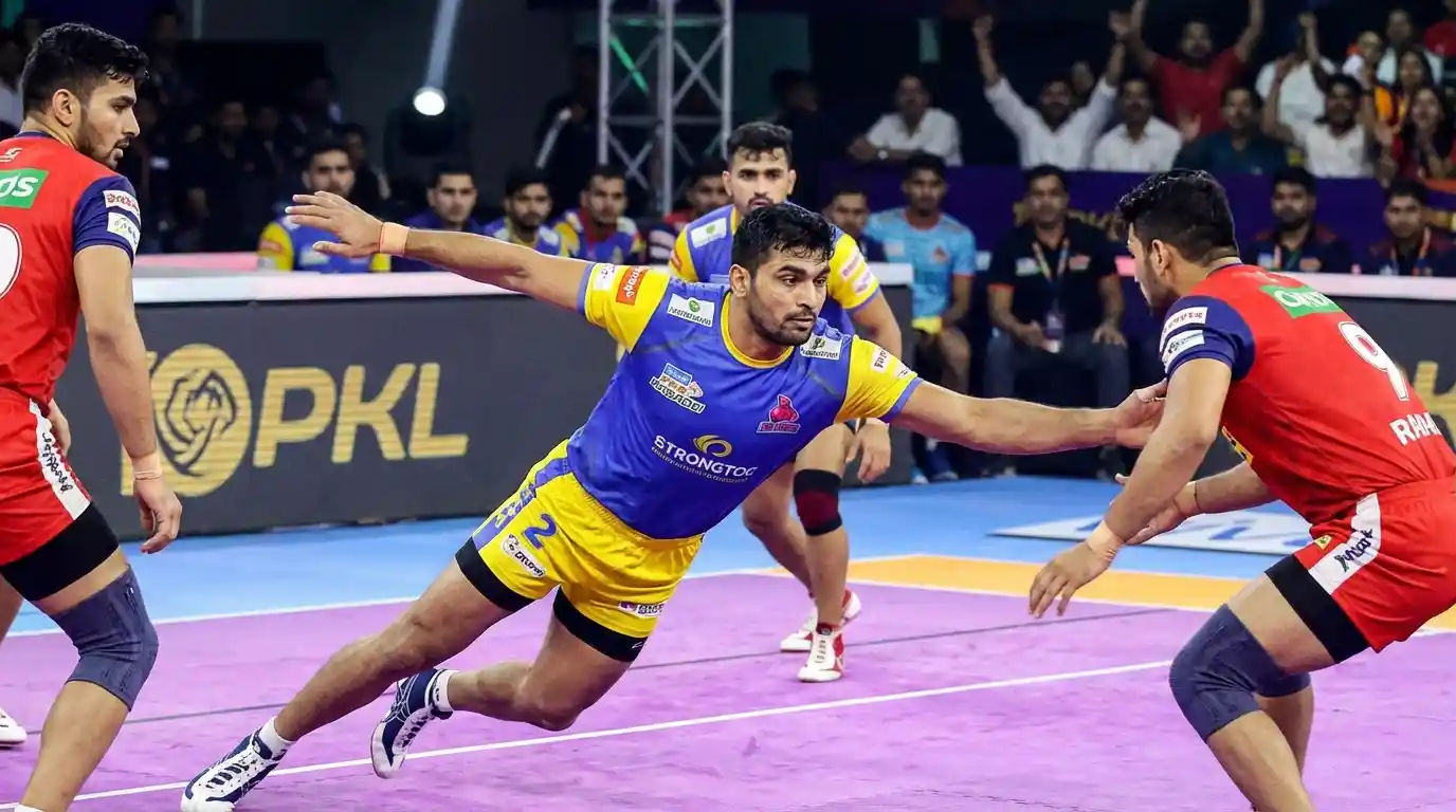 An intense moment: a Kabaddi raider lunging for a touch as the defenders close the gap.